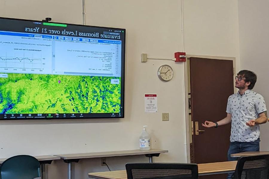 足彩平台 alum David Kolodziejski stands by a TV screen showing his work.