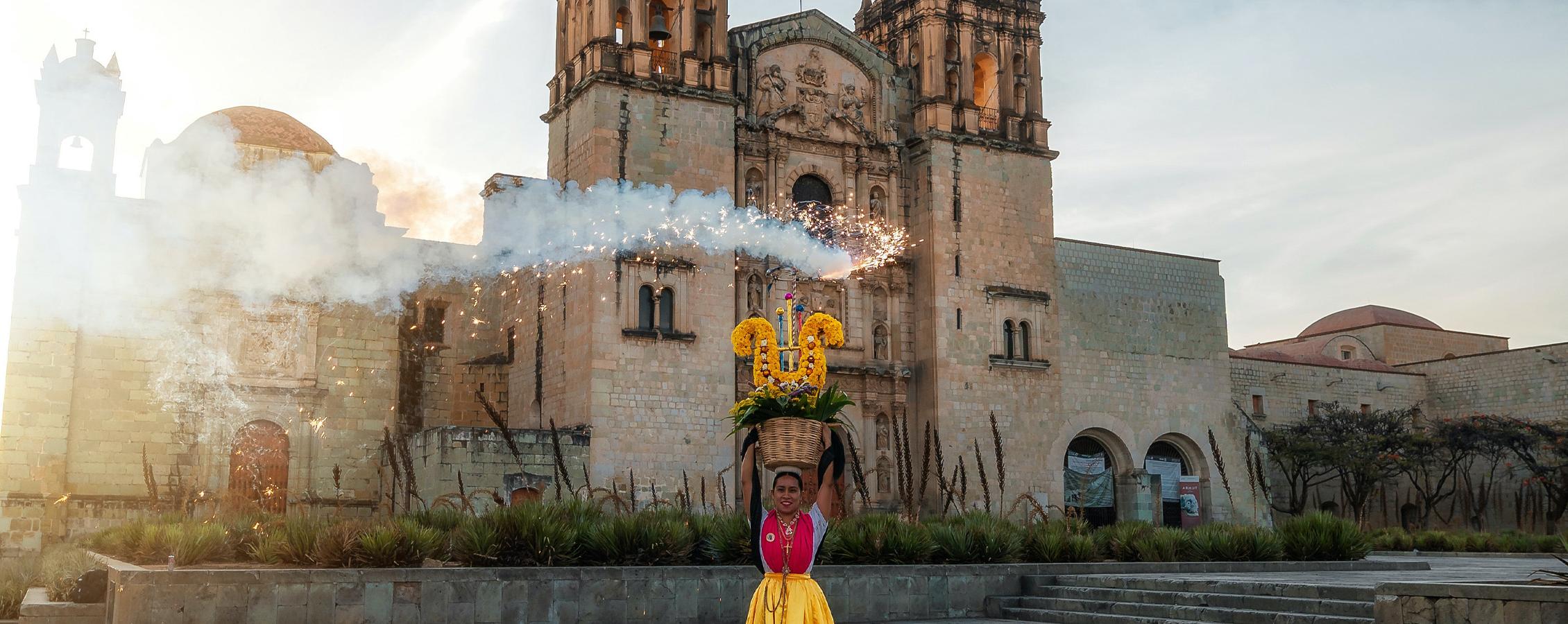 A person stands in front of a church in Mexico.