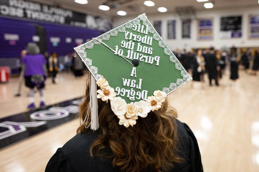 A student's cap at graduation says life liberty and the pursuit of a law degree.