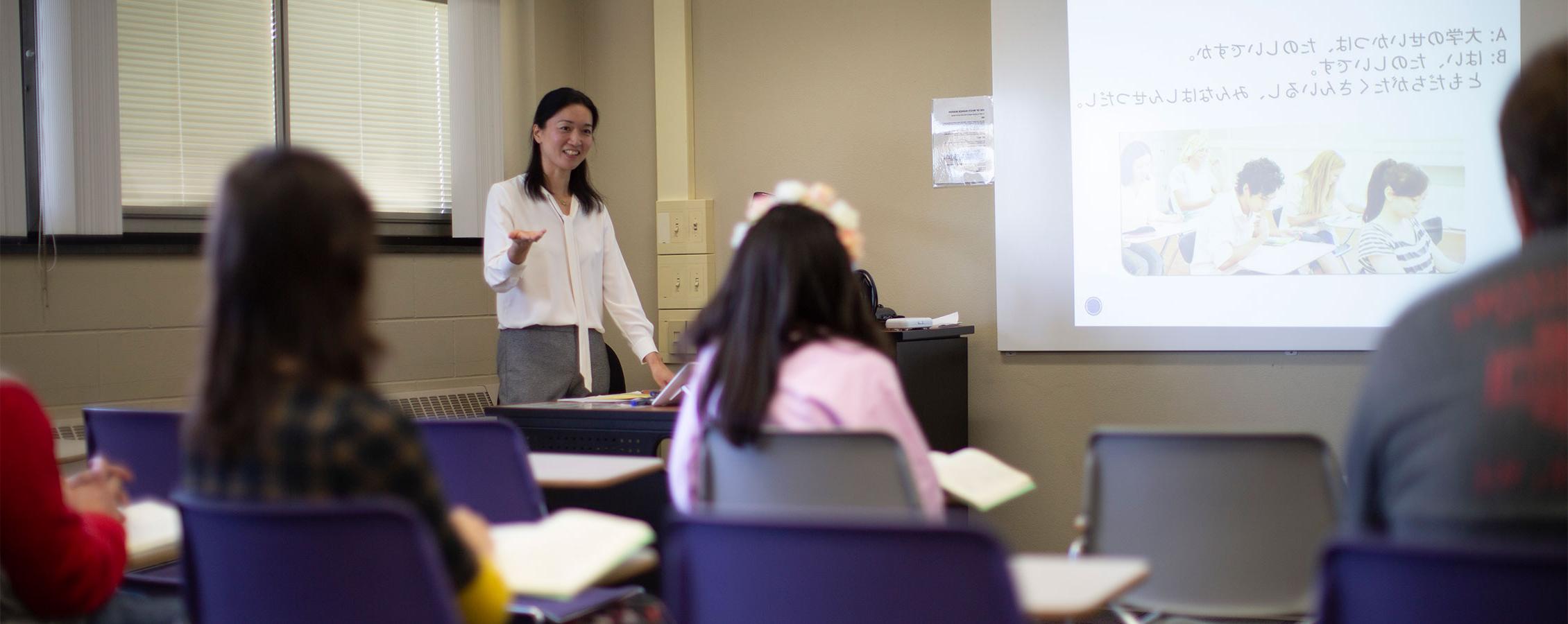 A faculty member stands in front of the class.