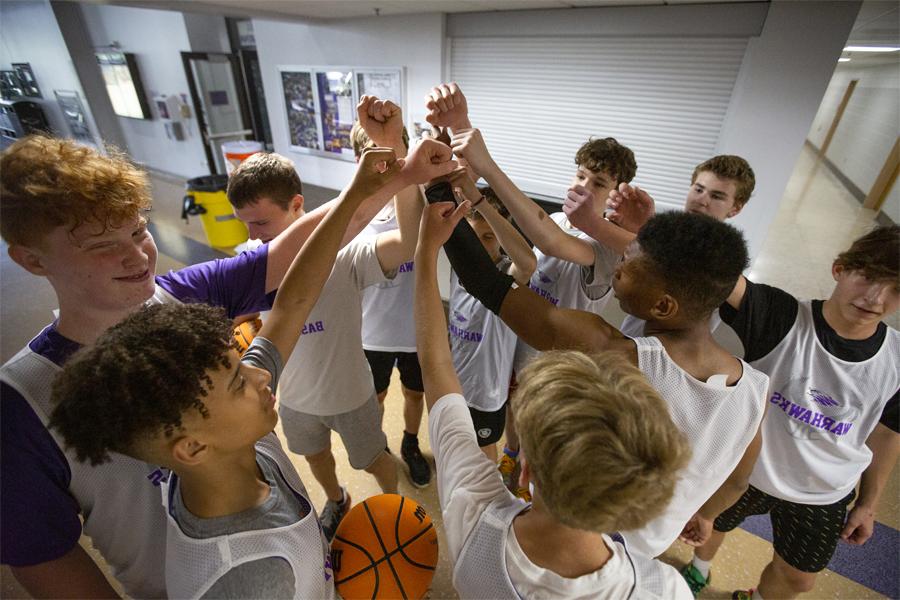 Boys basketball campers put their hands together.