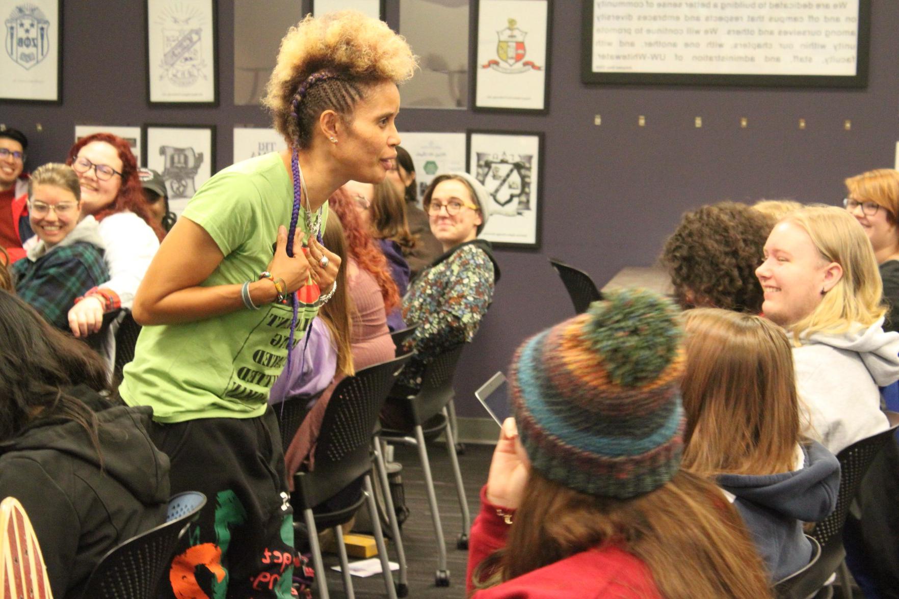 Staceyann Chin walks down an aisle of students in the Warhawk Connection Center while reading from her memoir. 