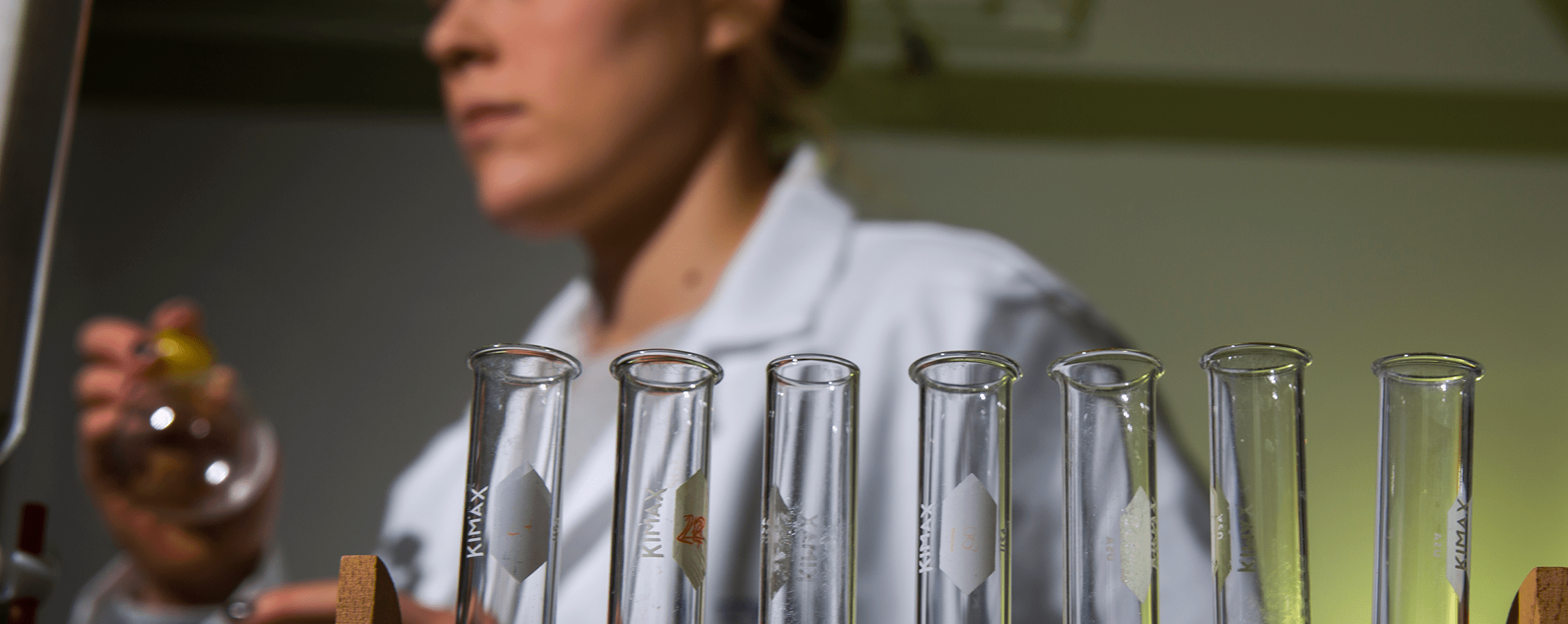 Student stand behind test tubes in a chemistry lab.