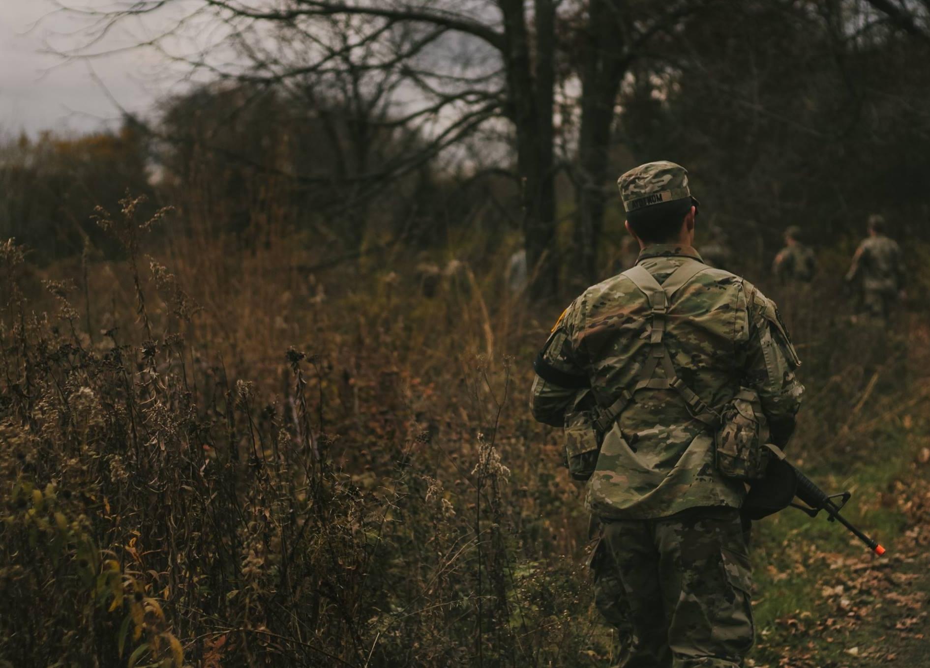 student in uniform on a mission through a field