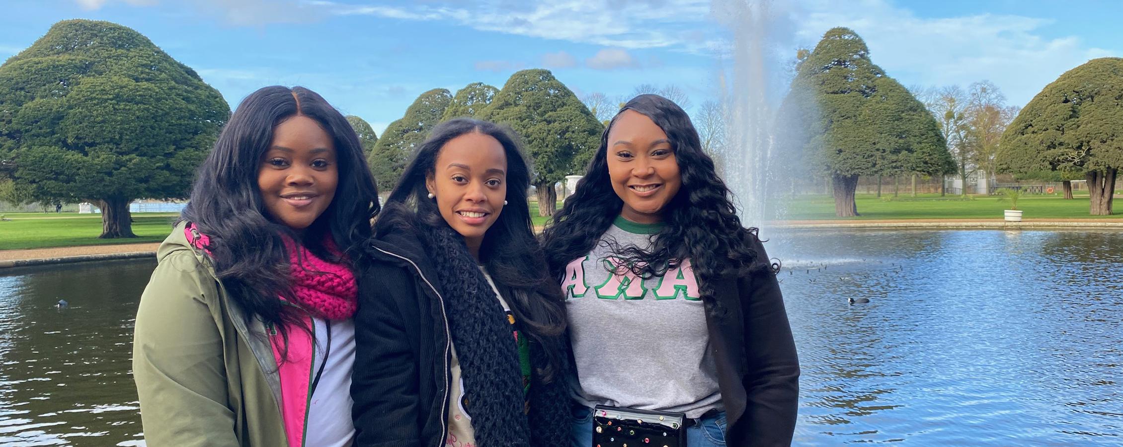 A group of people pose together in front of a fountain.