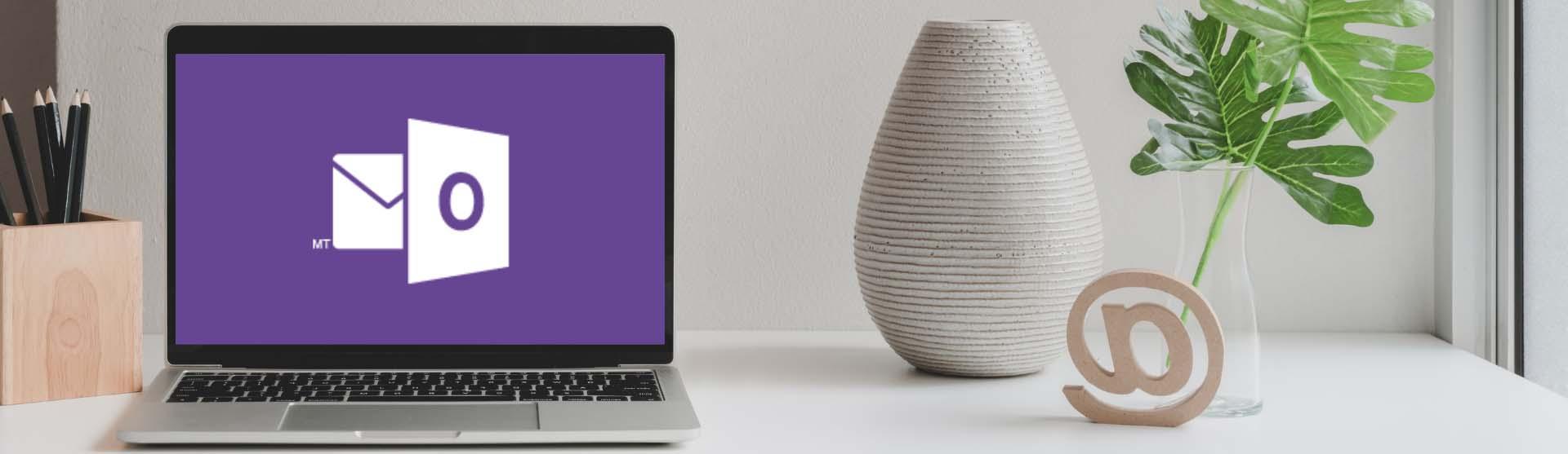 Laptop with a Warhawk purple Outlook logo next to a vase and trendy woodwork