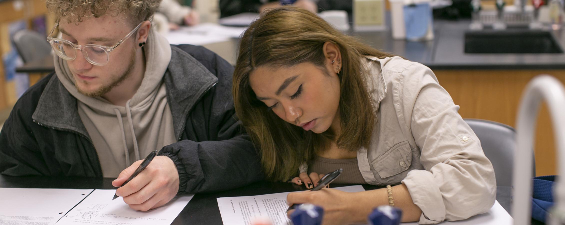 Two students work at a table.